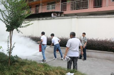 图为支行工作人员操作灭火器进行灭火演练