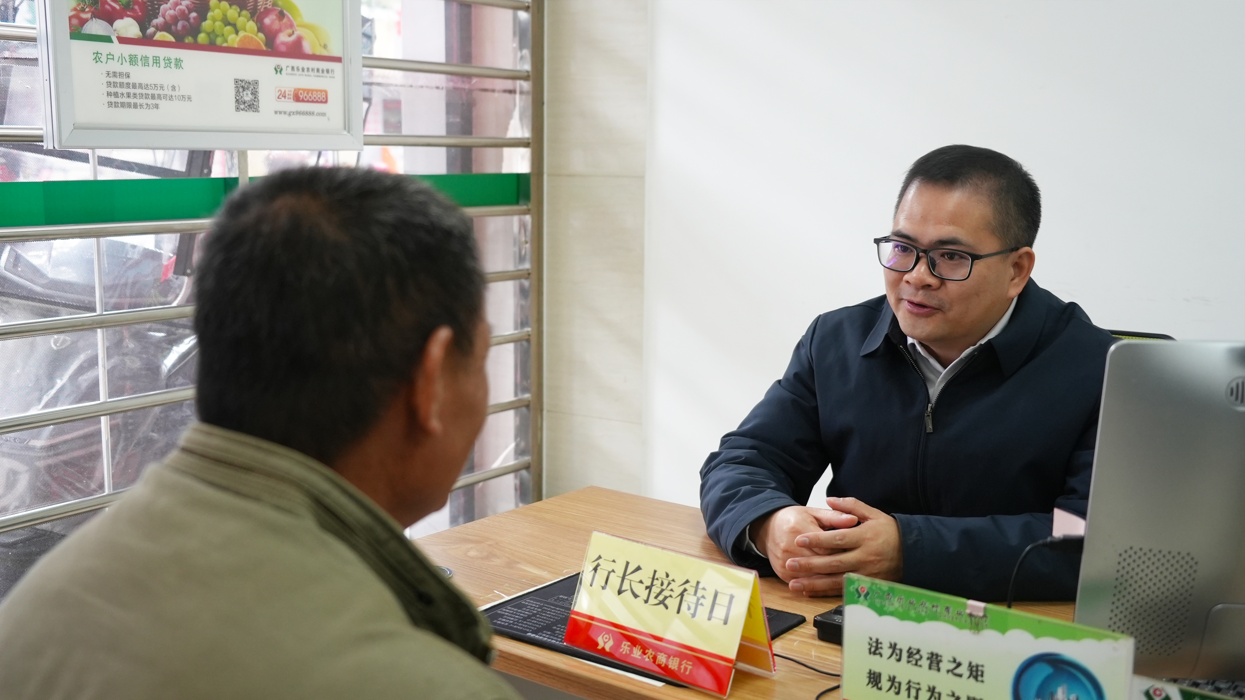 乐业农商银行党委委员、副行长罗日忠为客户答疑解难 乐业农商银行供图