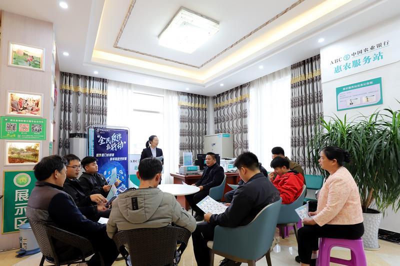 支行客户经理依托惠农服务站向种植户们宣传惠农政策、反诈知识等 农行浦北县支行供图