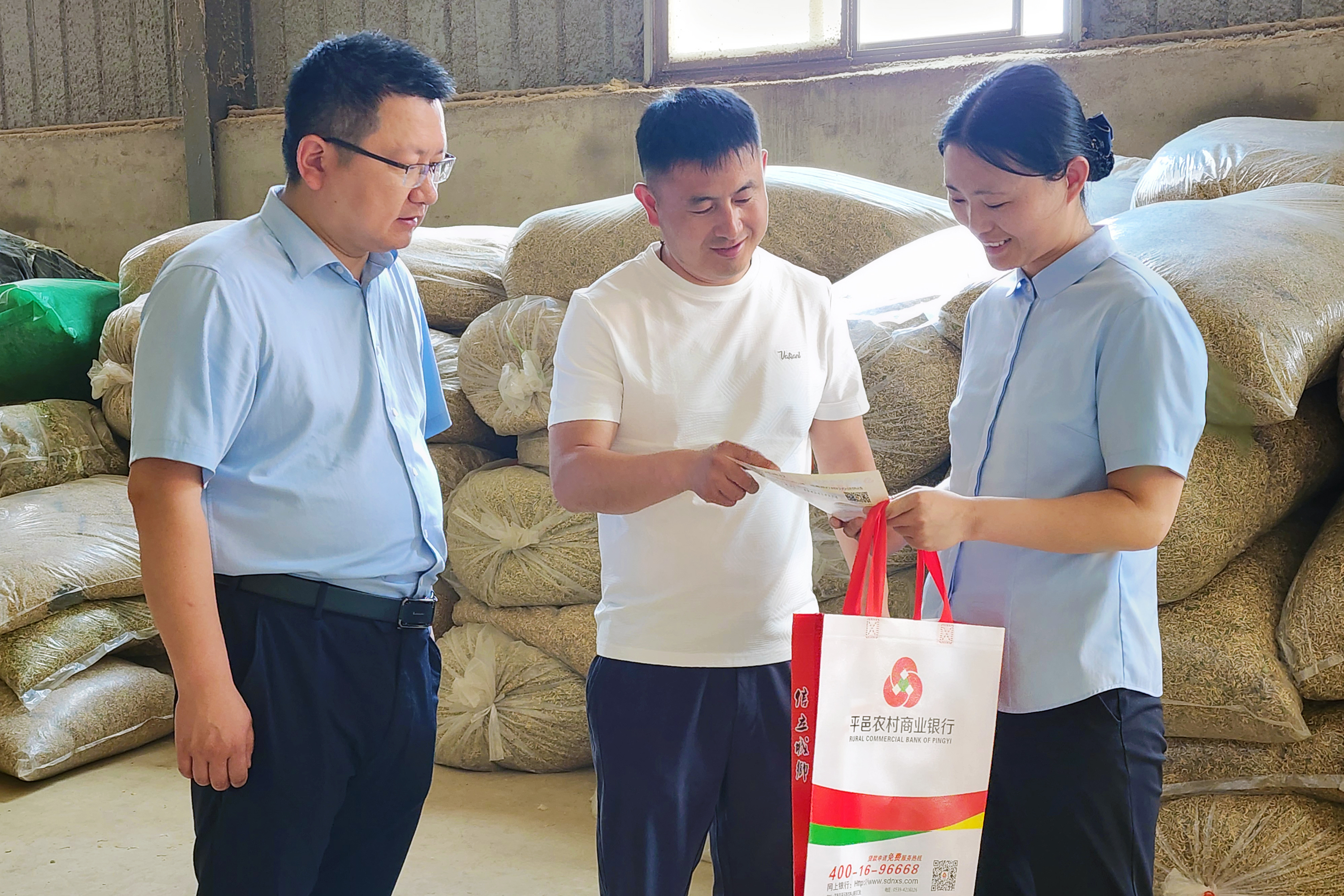 平邑农商银行客户经理向平邑芳华中药材有限公司负责人王进坤介绍信贷产品 平邑农商银行供图