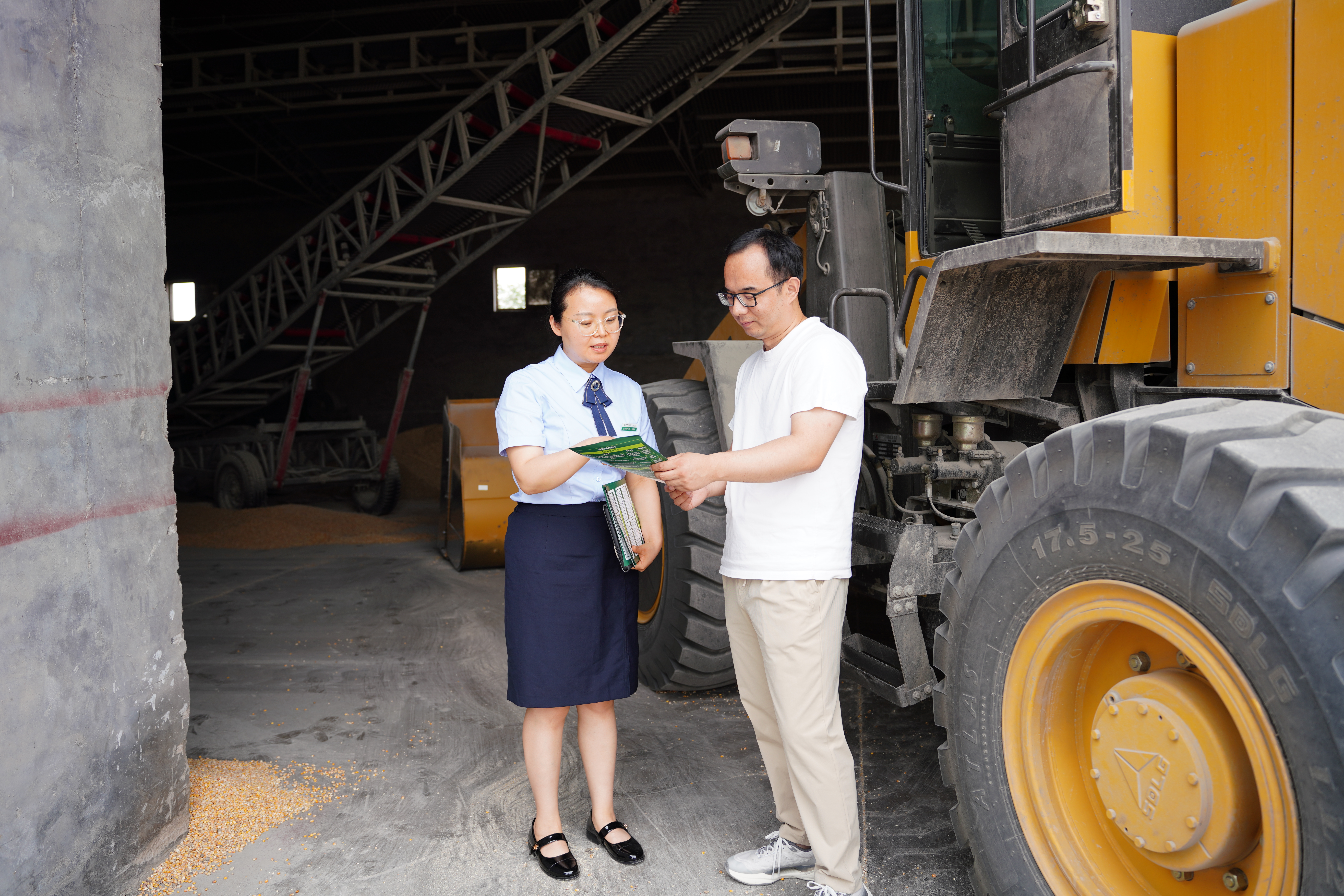 邮储银行新乡市分行客户经理娄娓娓(左)向刘安飞介绍信贷产品 (王凡星 摄)