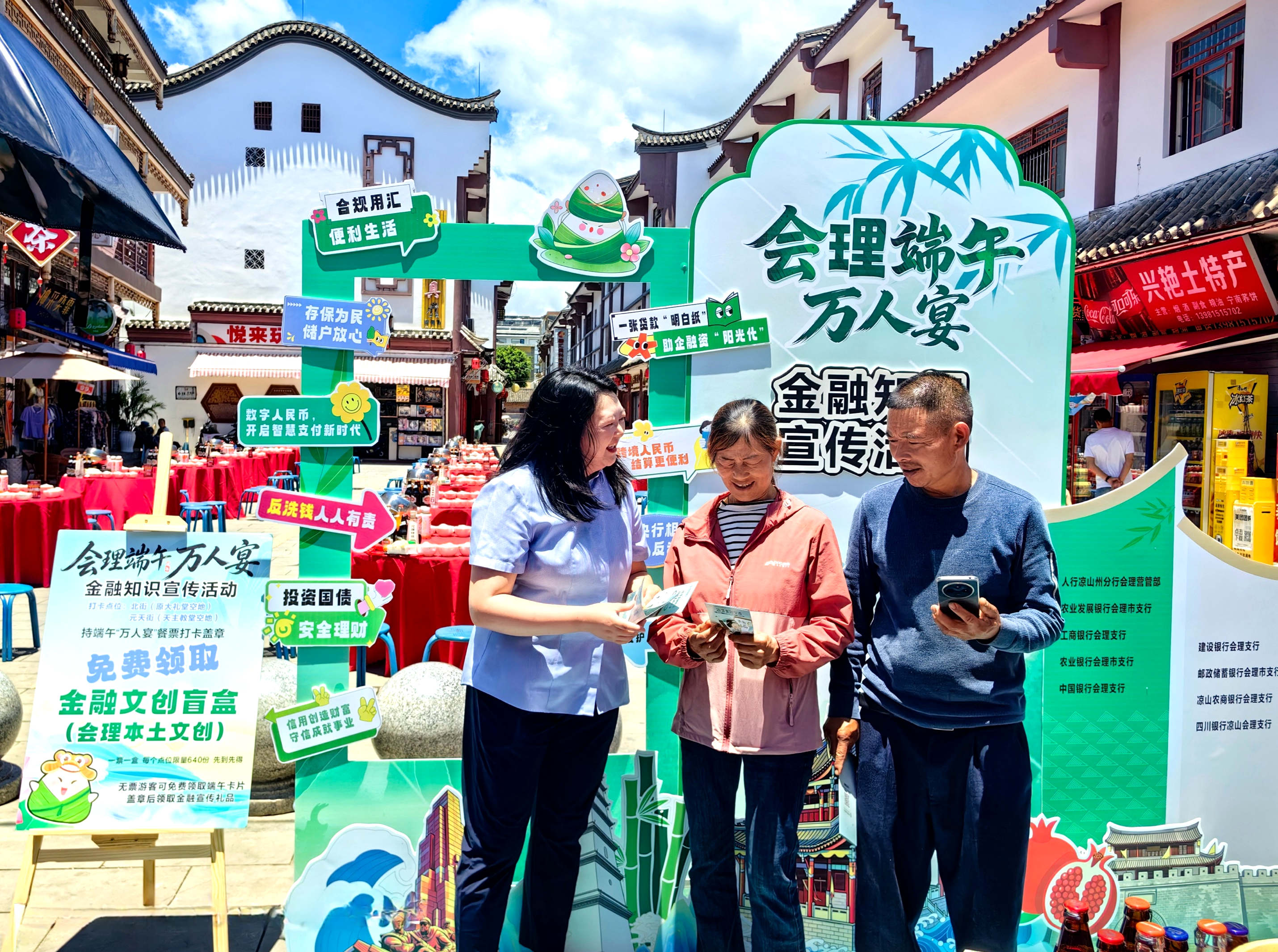 农行会理市支行党委书记、行长张红(左一)为群众讲解消保常识 农行会理市支行供图