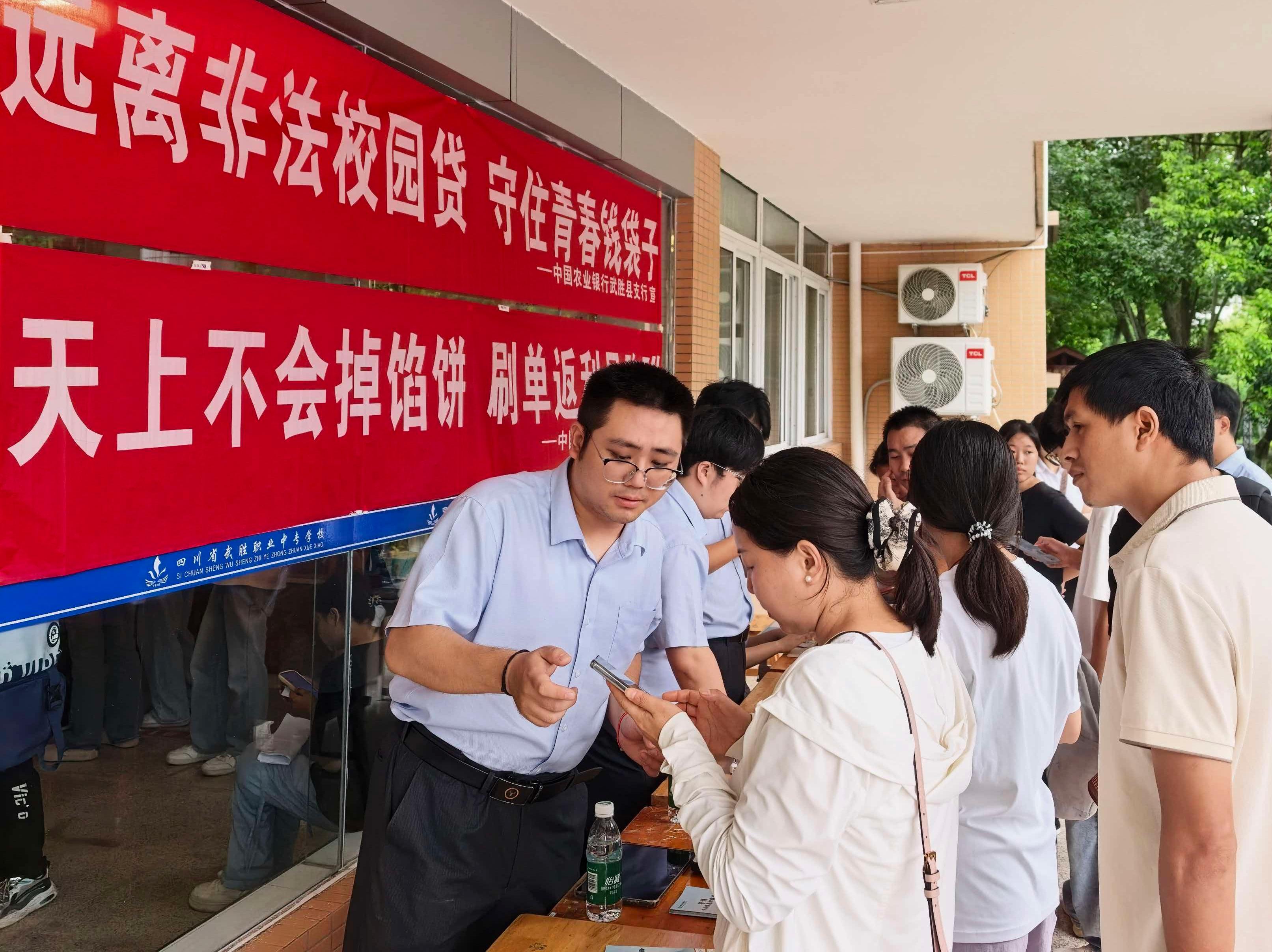 农行武胜县支行工作人员指导学生家长操作手机银行 农行武胜县支行供图